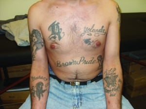 Figure 4. “Brown Pride” for racial identity as Hispanic or Latin; the anticubital fossa tattoos often cover intravenous drug abuse tracks, and the woman (right arm) is often the woman who “waits for him” during jail time. Yolanda is his girlfriend, and the left anticubital fossa tattoo is a tribute to a family member in the military, killed in service with “R.I.P.”, or rest in peace, noted above.